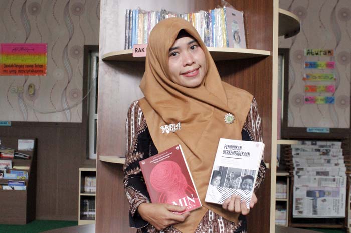 SENANG MENULIS: Myria Dian Farida memegang dua buku yang terdapat isi karyanya.