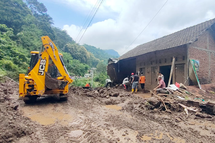 TUTUP JALAN: Relawan BPBD Kudus bersama warga melakukan proses evakuasi material tanah longsor di Desa Rahtawu kemarin.
