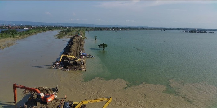 DIKEBUT: Foto udara pekerja mengerjakan penambalan tanggul Sungai Wulan di Dukuh Norowito yang jebol kemarin.