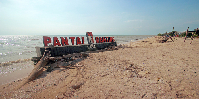 OLENG: Tembok bertuliskan Pantai Seribu Ranting di Desa Panggung, Kedung, rusak sebagian akibat terkikis abrasi air laut.