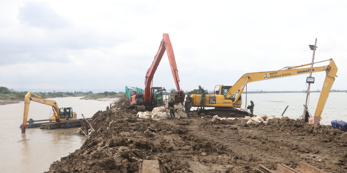 KERJA KERAS: Perbaikan tanggul Sungai Wulan menggunakan alat berat dari BBWS Pemali Juana dibantu petugas TNI di Dukuh Norowito, Desa Ketanjung, Karanganyar, Demak, kemarin.