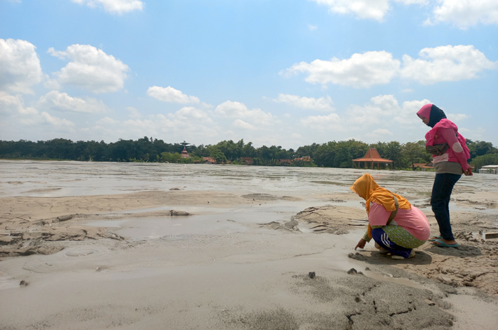 PENASARAN: Aktivitas baby volcano yang memuntahkan lumpur tarik perhatian warga sekitar untuk menyaksikan dari dekat kemarin.