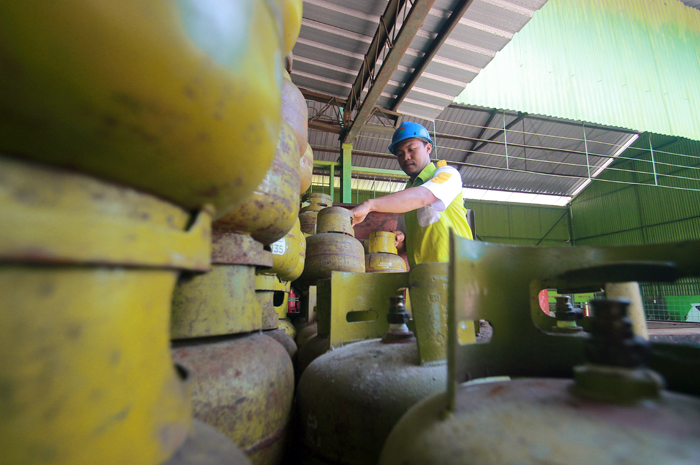 JAGA STOK: Petugas sebuah agen elpiji di Desa Kuwasen, Jepara Kota, menata tumpukan tabung elpiji melon sebelum didistribusikan ke pangkalan.