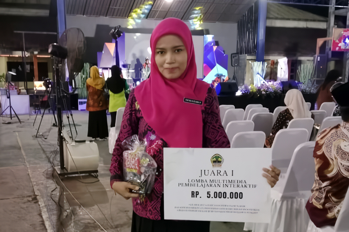 BERPRESTASI: Ratna Kusuma Ningrum membopong trofi juara I lomba multimedia pembelajaran interaktif di Alun-alun Purwodadi baru-baru ini.