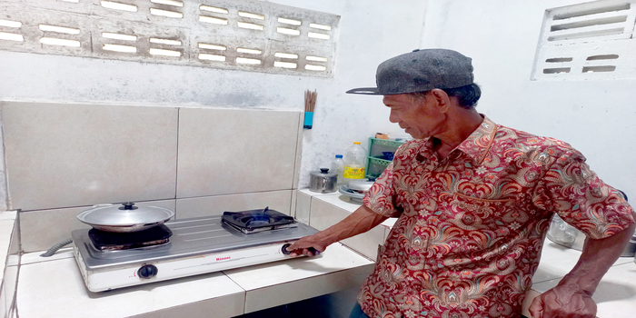 MELIMPAH: Pengelola BUMDes Rajek Sarmadi menunjukkan kompor dengan nyala api biru yang sehari-hari digunakan memasak berbahan bakar gas alam kemarin.
