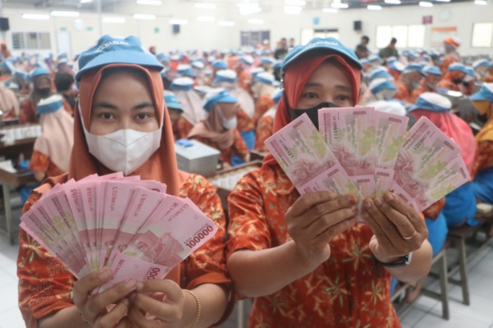 Buruh PT Djarum Kudus memperlihatkan uang THR di Brak Bitingan, Krajan, Panjunan, Kecamatan Kudus Kota pada Selasa (2/4).