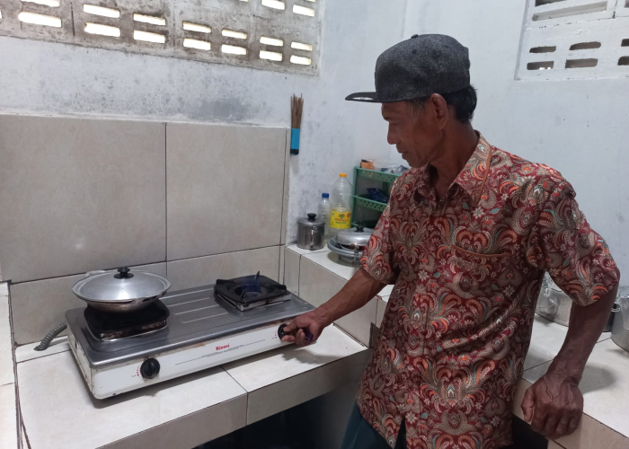 MELIMPAH: Pengelola BUMDes Rajek Sarmadi menunjukkan kompor dengan nyala api biru yang sehari-hari digunakan memasak berbahan bakar gas alam.