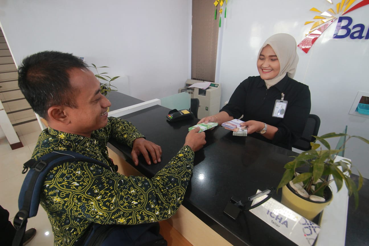 BARU: Seorang nasabah menukarkan uang baru untuk Lebaran di kantor Bank Jateng Cabang Jepara kemarin.