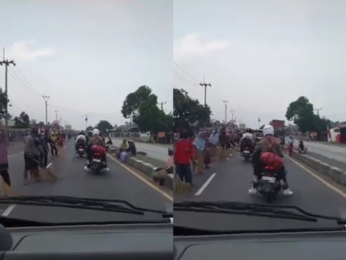 Tradisi warga Indramayu berjejer di sepanjang jalan Jembatan Sewo sambil membawa sapu lidi dan mengais koin.