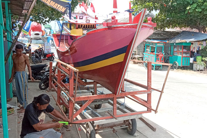 PREPARE: Warga membawa replika kapal untuk mempersiapkan kegiatan sedekah laut Desa Tasikagung kemarin.