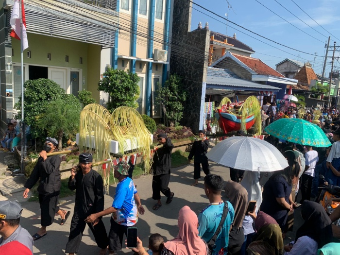 Warga menyaksikan sesaji yang akan dilarung di muara dalam tradisi sedekah laut yang digelar Desa Bendar Kecamatan Juwana Minggu (21/4).