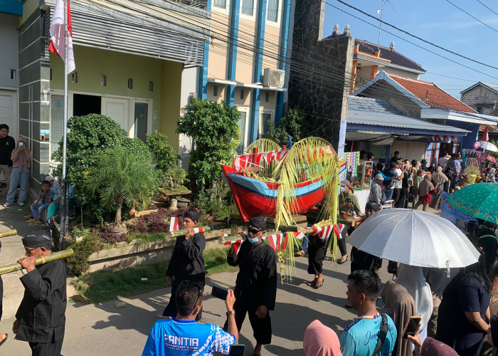 SEDEKAH LAUT: Warga menyaksikan sesaji yang akan dilarung di muara dalam tradisi sedekah laut yang digelar Desa Bendar Kecamatan Juwana pada Minggu (21/4) pagi.