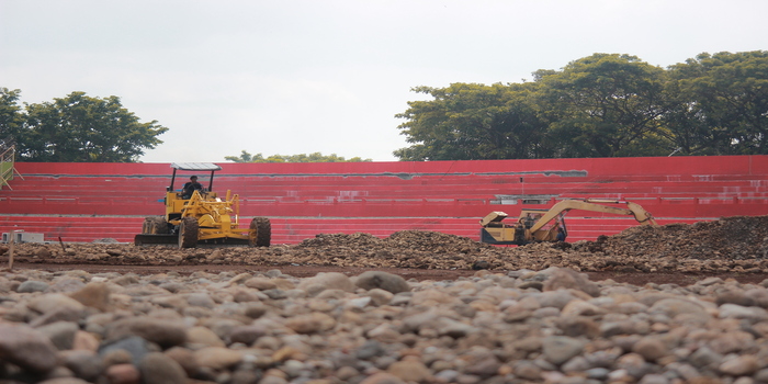 KEBUT: Pekerja meratakan lapisan area lapangan Stadion GBK Jepara saat proses renovasi.
