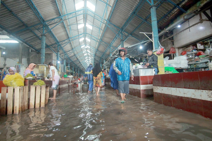 DIUSULKAN LAGI: Pedagang dan pembeli beraktifitas di tengah genangan air yang merendam komplek Pasar Jepara 2 saat hujan deras.