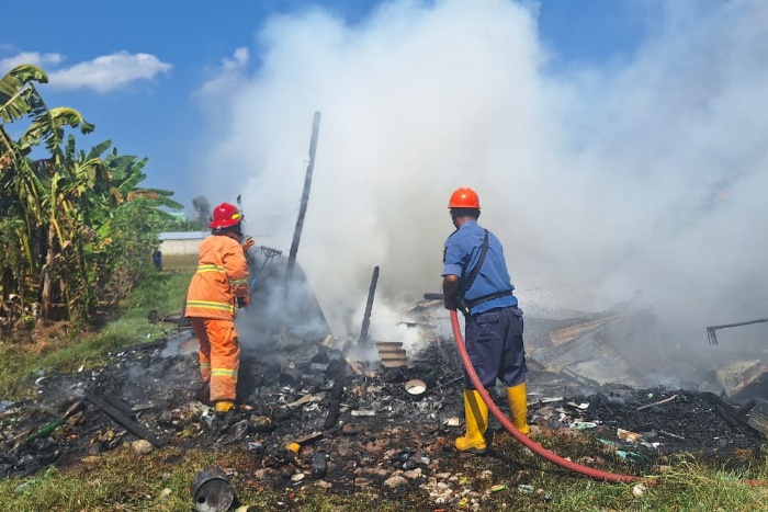 DIPADAMKAN: Petugas dibantu warga berjibaku memadamkan gudang rosok dan gudang bekas batik.