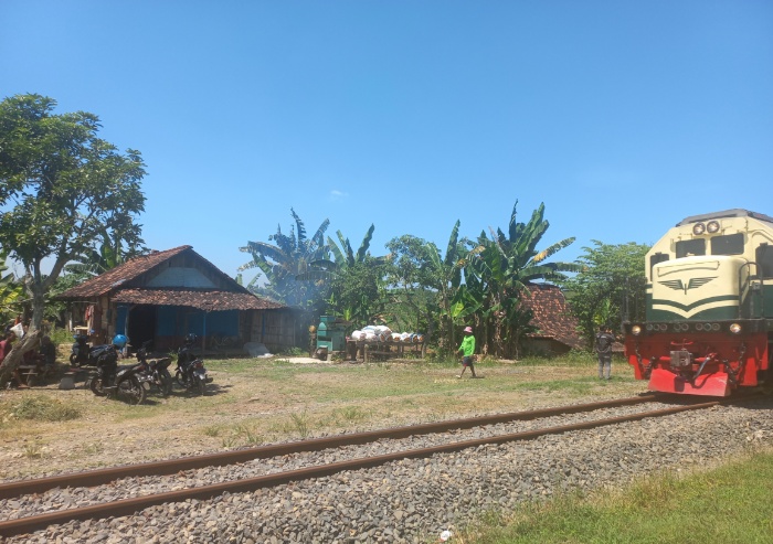 BERTAHAN: Kereta api tampak melintas di depan permukiman warga Dusun Rejosari yang berada di wilayah hutan Desa Sugihmanik baru-baru ini.