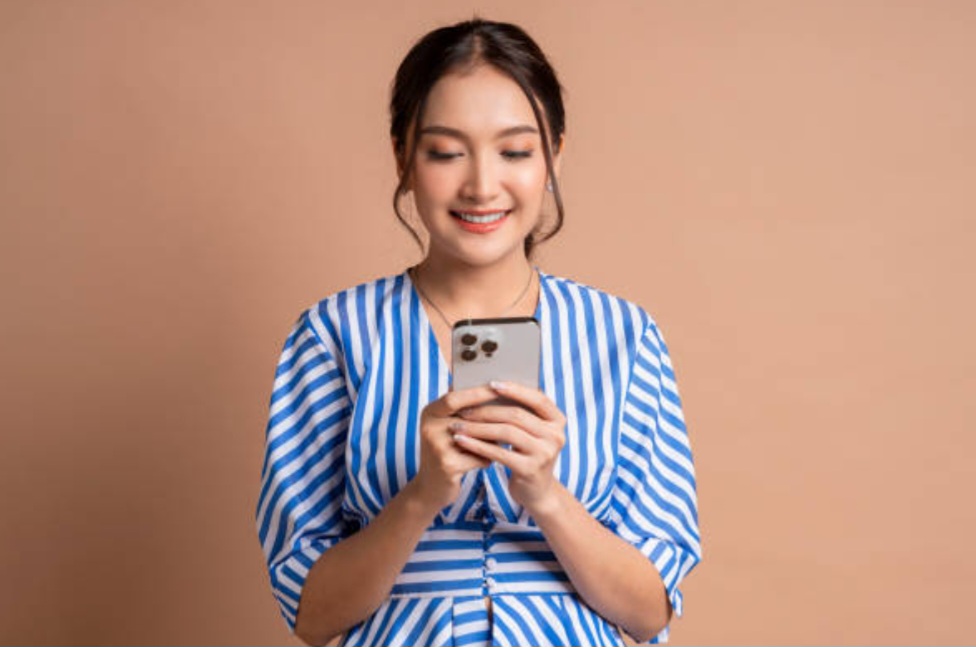 ADA PESAN: Orang sedang membaca pesan melalui handphone.