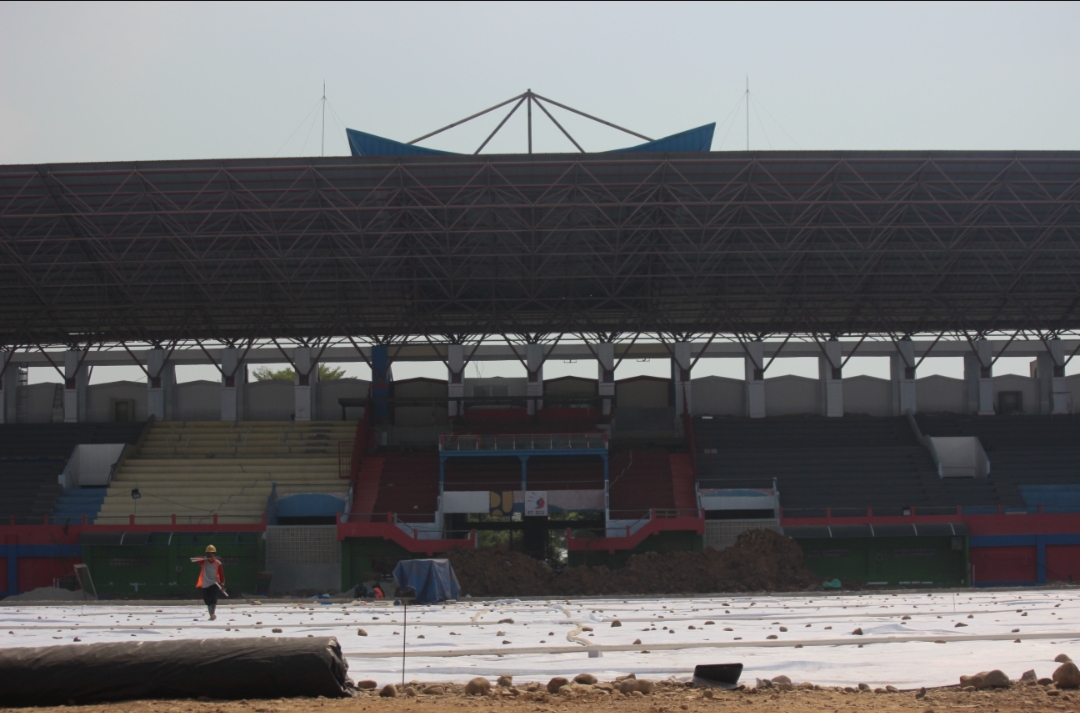 BARU: Pekerja melintas di atas lapangan Stadion GBK Jepara yang akan segera ditanami rumput bulan depan.
