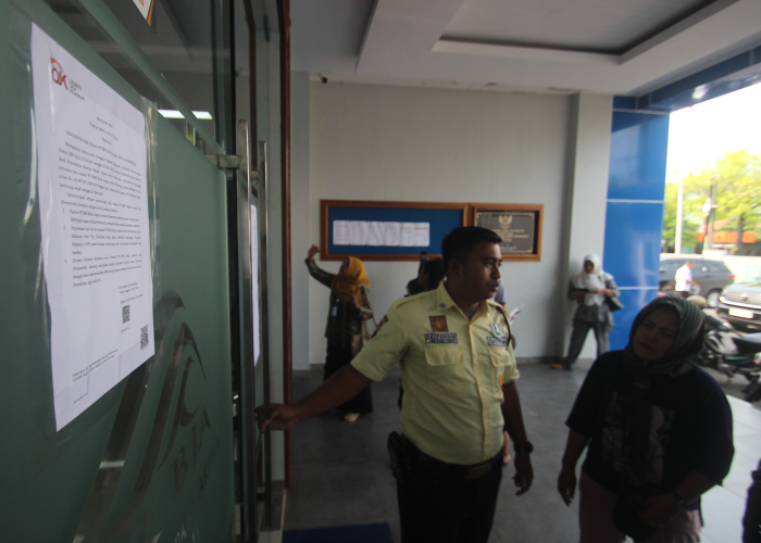 MENANTI KEPASTIAN: Masyarakat mengantre untuk mendapat informasi terkait tabungan mereka yang tersimpan di BJA usai izin usahanya dicabut pada Rabu (22/5).