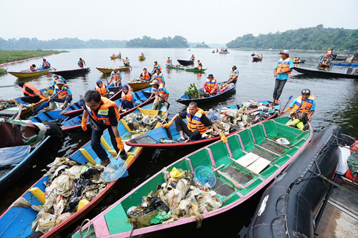 JAGA LINGKUNGAN: Pegawai PLN bersama komunitas dan para pemangku kepentingan kolaborasi menggunakan perahu membersihkan Waduk Saguling di Kabupaten Bandung Barat, Jawa Barat, Senin (3/6).
