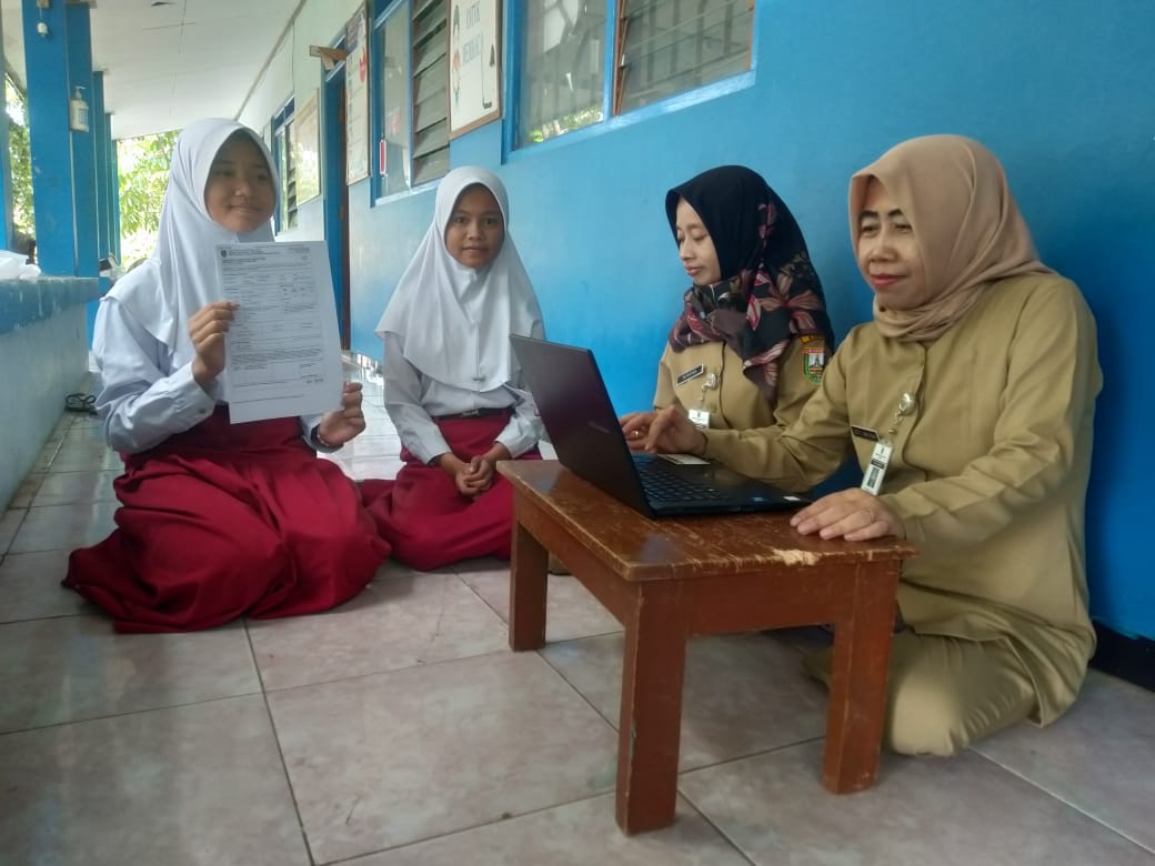 MENDAFTAR: Guru SD 2 Sambung membantu siswanya mendaftarkan PPDB SMP secara online di sekolah kemarin.