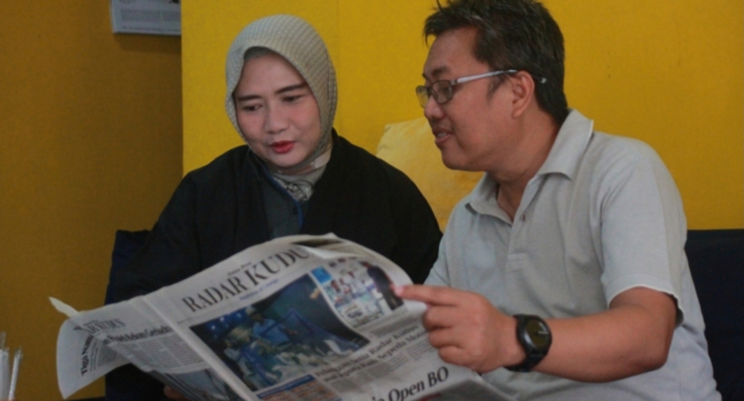 SETIA: Pasangan suami istri Johan Teguh Widodo dan Risya Farida, pemenang motor dalam undian Gebyar Pembaca Setia membaca koran Jawa Pos di teras rumahnya pada Selasa (2/7).