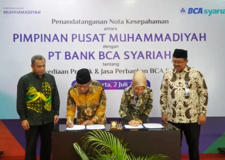KERJASAMA: Haedar Nashir Ketum PP Muhammadiyah (batik kuning kiri) menandatangani kerjasama dengan PT Bank BCA Syariah. Foto: muhammadiyah.or.id