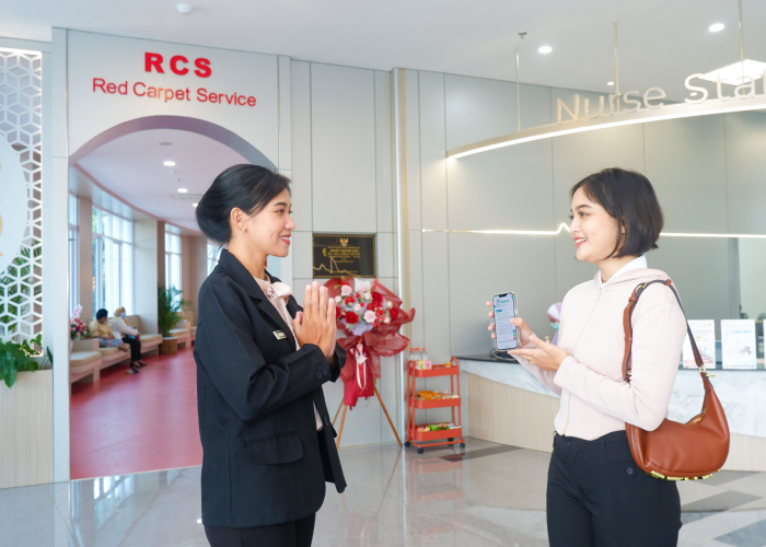 SELAMAT DATANG : Petugas dari Red Carpet Service menyambut pengunjung yang akan periksa.