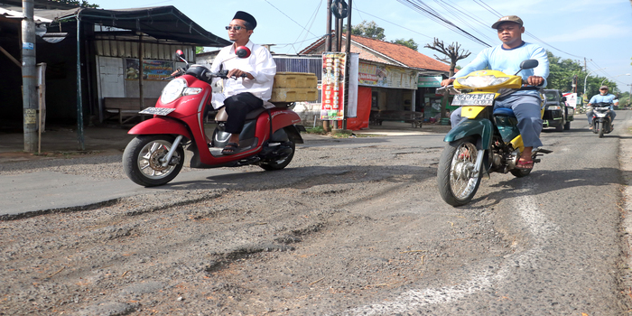 LUBANG MENGANGA: Pengendara menghindari lubang jalan yang mengalami kerusakan parah saat menuju wisata Pegunungan Rahtawu tepatnya di Jalan Rahtawu Raya Desa Gebog Kudus.