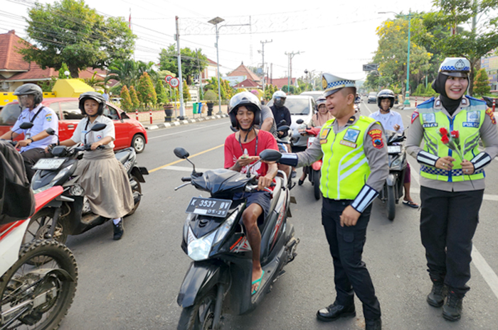 HUMANIS: Satlantas Polres Jepara saat memberikan bunga kepada pengendara yang tertib lalu lintas.