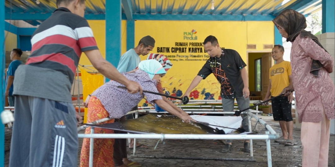 PRODUKSI: Pengelola Batik Ciprat, Yoyok Ernowo (ketiga dari kanan) bersama para pekerja difabel melakukan serangkaian proses produksi batik dengan metode splatter.