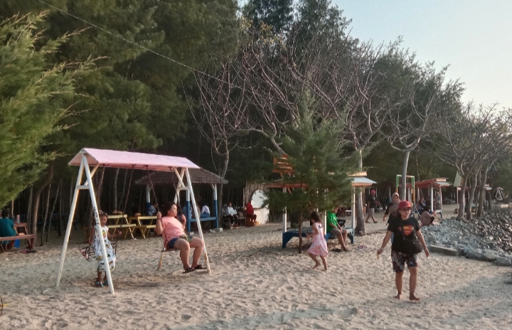 SANTAI: Wisatawan sedang bermain ayunan di Pantai Wates