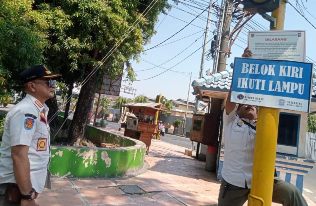 PASANG PERINGATAN: Satpol PP memasang papan informasi tentang Perda Larangan Mengemis dan Memberi kepada Pengemis di salah satu lampu lalu lintas baru-baru ini.