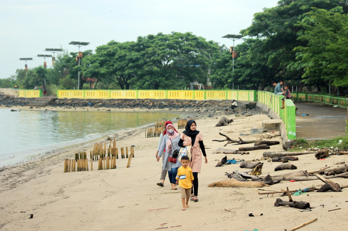 POTENSIAL: Wisatawan berjalan di atas hamparan pasir putih yang ada di Pantai Pungkruk, Desa Mororejo, Mlonggo, Jepara.