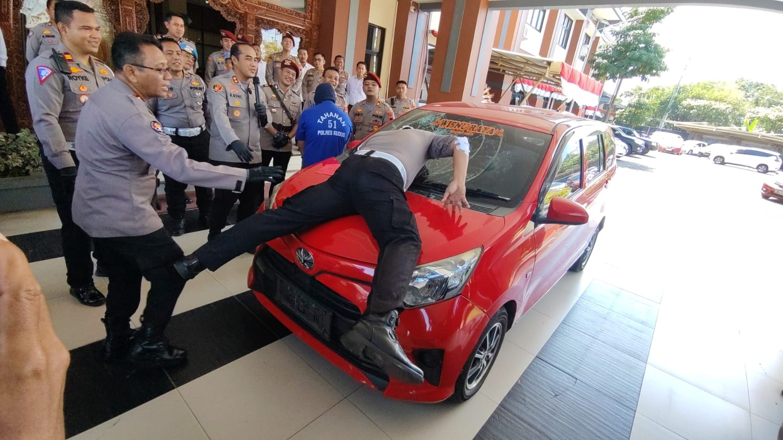 PRAKTIK: Aipda Suprihadi mempraktikkan saat dirinya menghentikan tersangka dan sempat menyangkut di atas kap mobil.