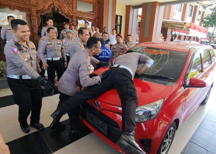 DIRINGKUS: Aipda Suprihadi mempraktikkan saat dirinya menghentikan tersangka dan sempat menyangkut di atas kap mobil.