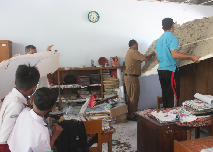 RUSAK: Siswa dan guru SDN Sendanggayam saat membersihkan plafon yang ambrol.