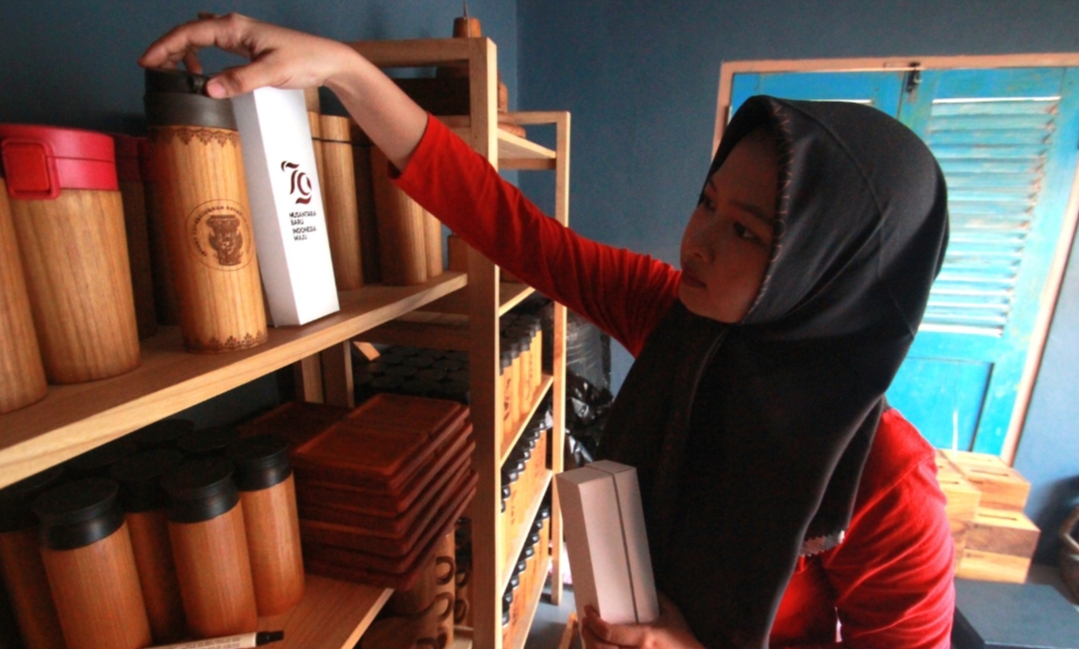 KEBANGGAAN: Seorang karyawan menata tumbler kayu jati produksi SAE Wooden yang akan diberikan sebagai cinderamata kepada para tamu upacara HUT RI di IKN mendatang.