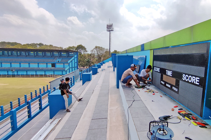 DIKEBUT: Proses pemasangan papan skor digital di tribun timur Stadion Wergu Wetan.