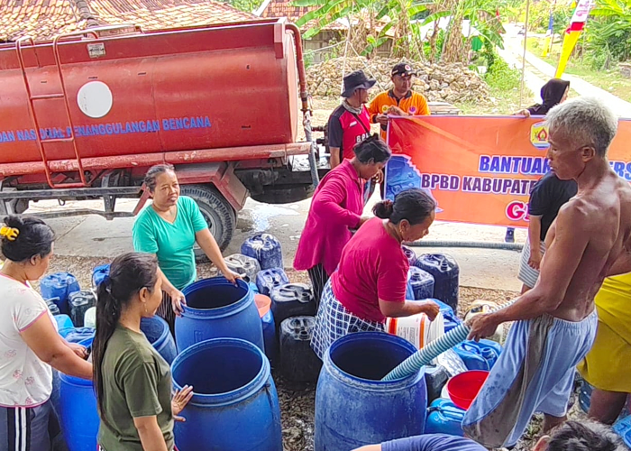 DROPPING AIR: Warga Desa Pojok, Kecamatan Tawangharjo berbondong-bondong mengambil bantuan air bersih dari BPBD Grobogan dan asosiasi wartawan setempat baru-baru ini.