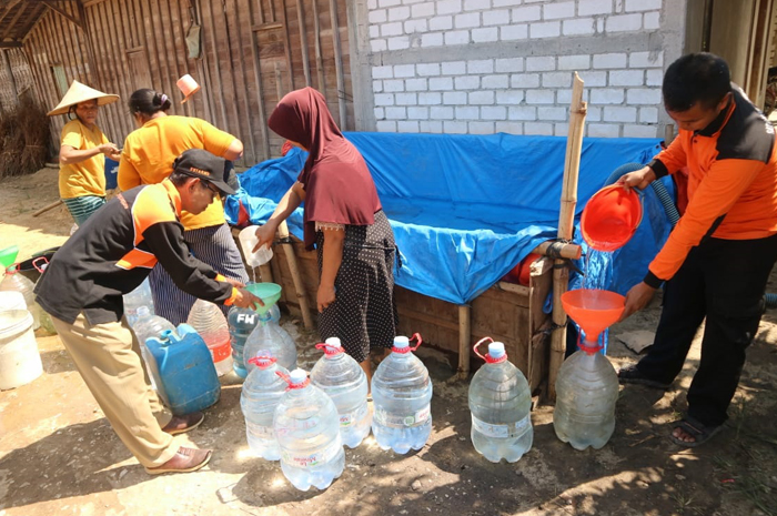 DITAMPUNG DI TERPAL: Masyarakat Desa Mantingan Tengah, Jaken, mengambil air di penampungan dari bantuan, Selasa (13/8).