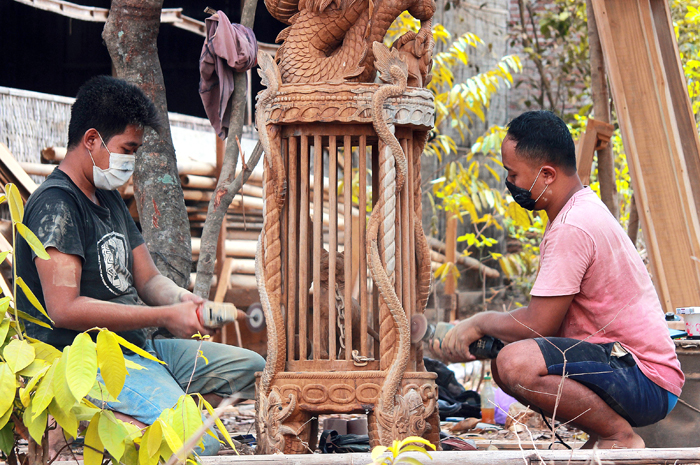 TAK ADA DUANYA: Perajin membuat ukiran macan kurung di sentra pembuatan patung kayu Desa Mulyoharjo, Jepara.