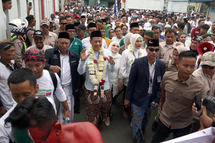 DIIRING PENDUKUNG: Paslon Bacabup-Bacawabup Kudus Sam&rsquo;ani Intakoris-Bellinda Birton (hem putih) saat akan masuk kantor KPU Kudus untuk mendaftar untuk bertarung di Pilkada Kudus kemarin.