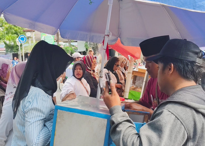 GRATISKAN: Warga Kota Purwodadi antusias antre untuk membeli jajanan yang dijual pedagang yang digratiskan karena nadar Paslon Bambang-Catur bisa daftar ke KPU.