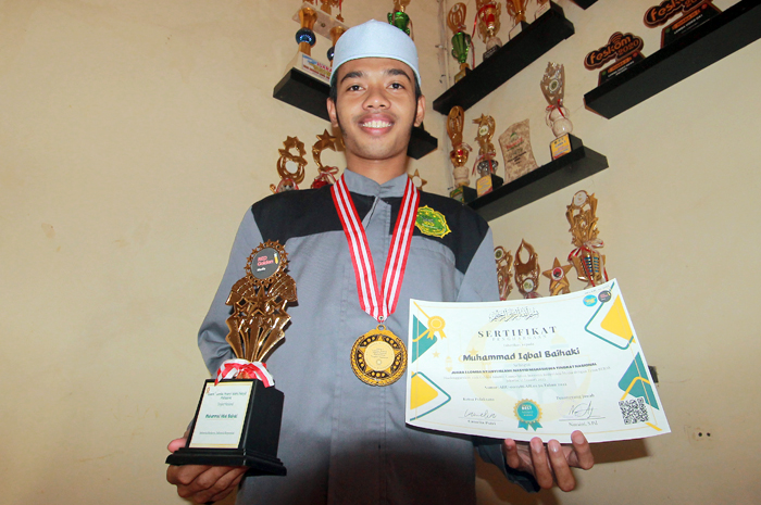 JEMAWA: M. Iqbal Baihaki, mahasiswa Unisnu Jepara menunjukkan penghargaan yang didapat setelah jadi juara 1 lomba MTQ dan tilawah nasional.