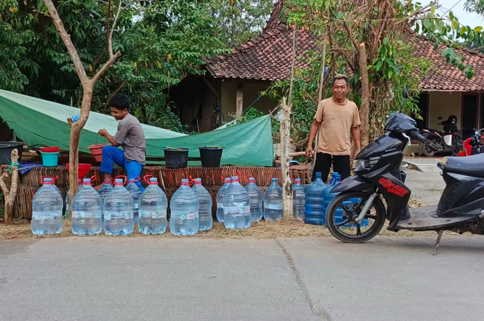 DIBANTU: Masayarat Desa/Kecamatan Gabus mengambil air di penampungan salah satu rumah warga belum lama ini.