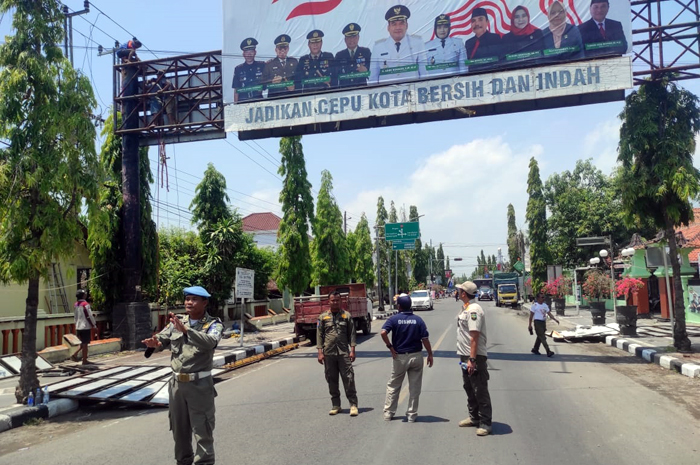 PENERTIBAN: Satpol PP Kabupaten Blora melakukan penurunan bando baliho di Kecamatan Cepu.