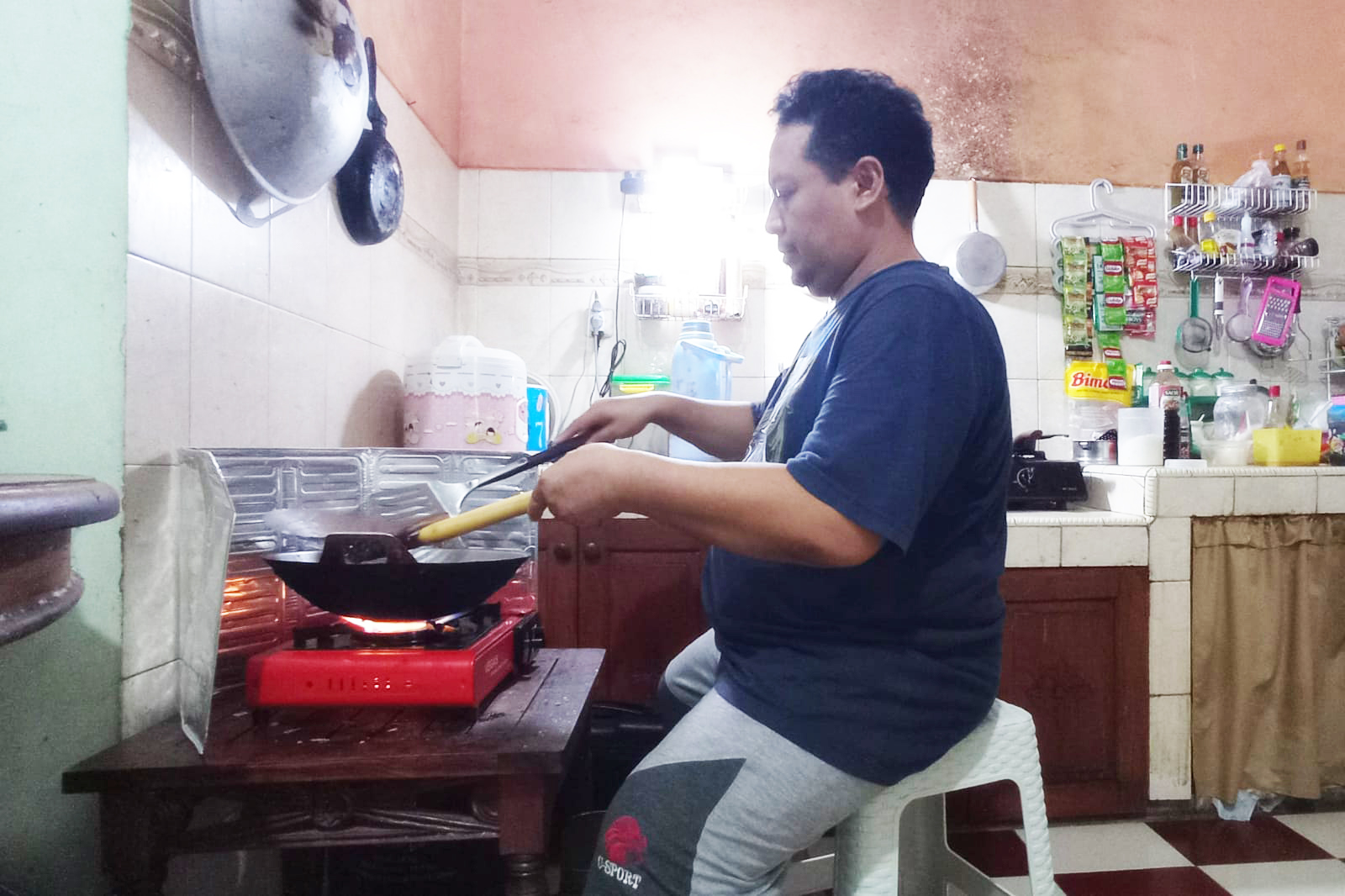 KEPEPET: Warga Desa Bawu, Anis Hartanto terpaksa memasak menggunakan kompor dan gas portabel karena tak dapat LPG 3 kilogram kemarin. (FIKRI THOHARUDIN/RADAR KUDUS)
