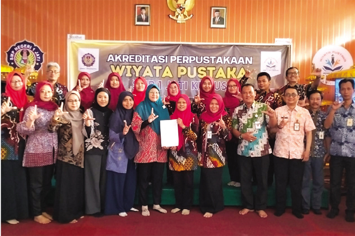 GALAKKAN LITERASI: Para guru SMP 1 Jati berfoto menunjukkan akreditasi perpustakaan.