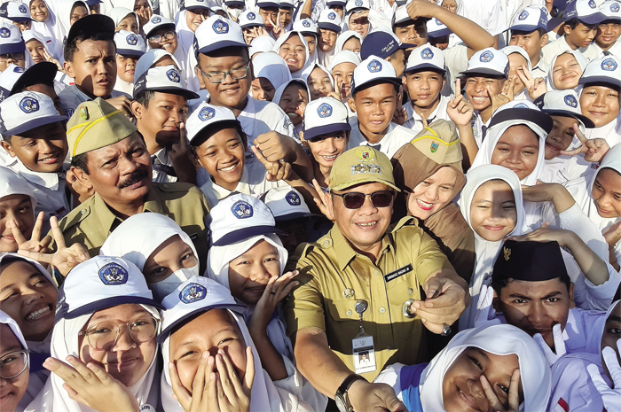 MAJU BERSAMA: Pj Bupati M. Hasan Habibie (tengah) selfie dengan Kepala Disdikpora Kudus (berseragam dinas kiri), Kepala SMP 1 Jati Sumaryatun (berseragam dinas kanan), dan para siswa.